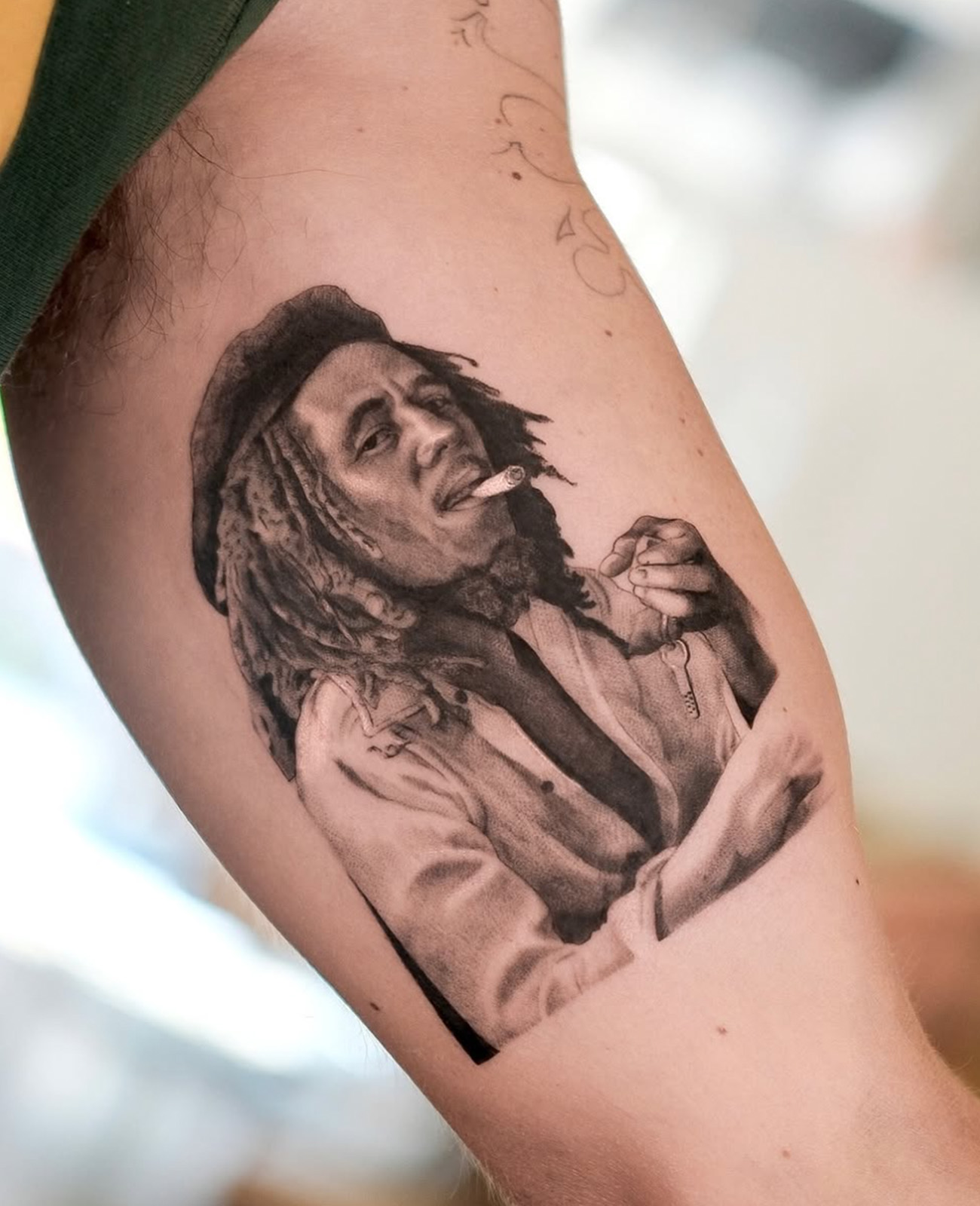 Black and grey realism tattoo from bob marley on white skin